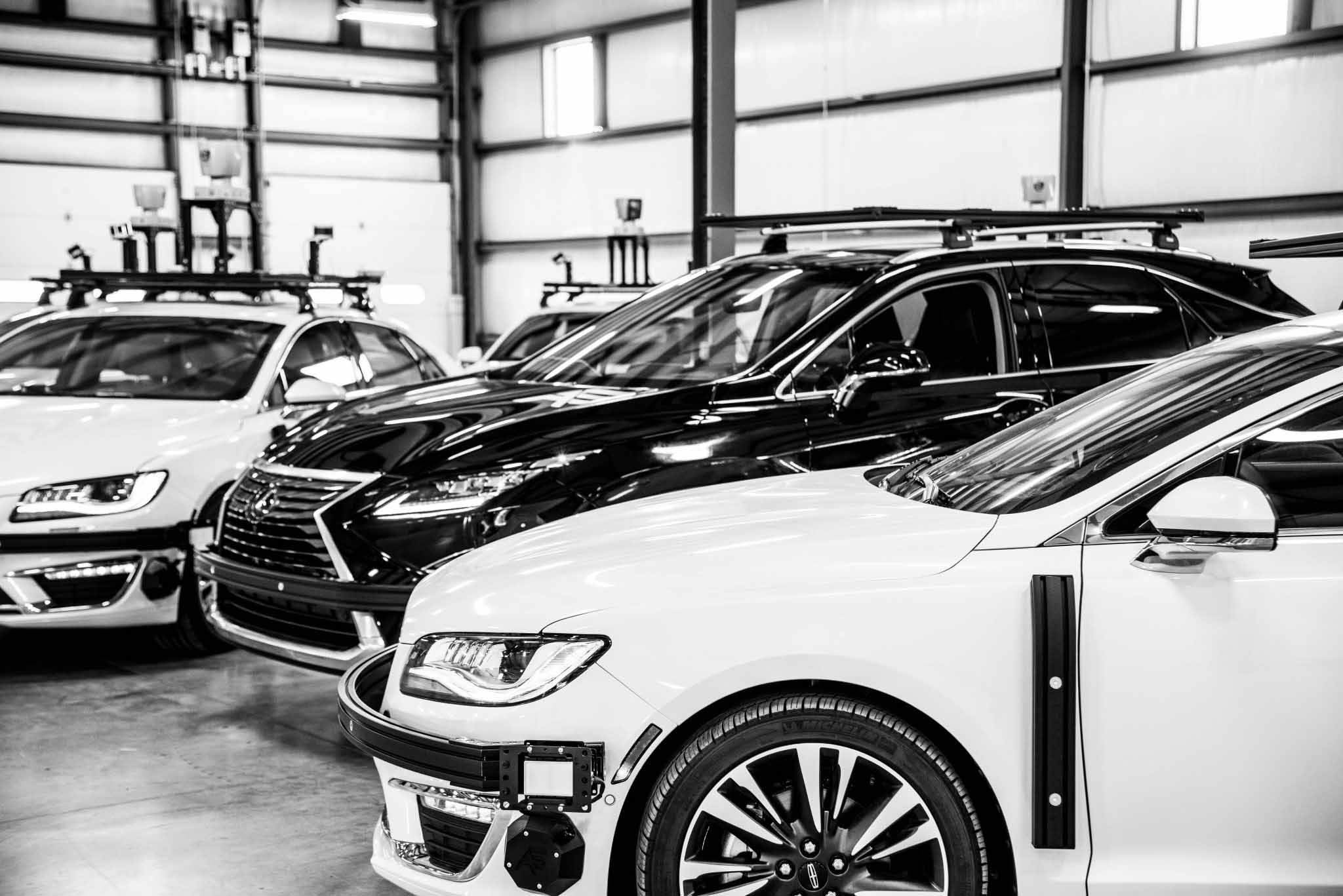 Black and white photo of vehicles in a showroom
